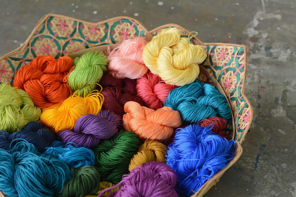 Colorful yarn balls in a woven basket.