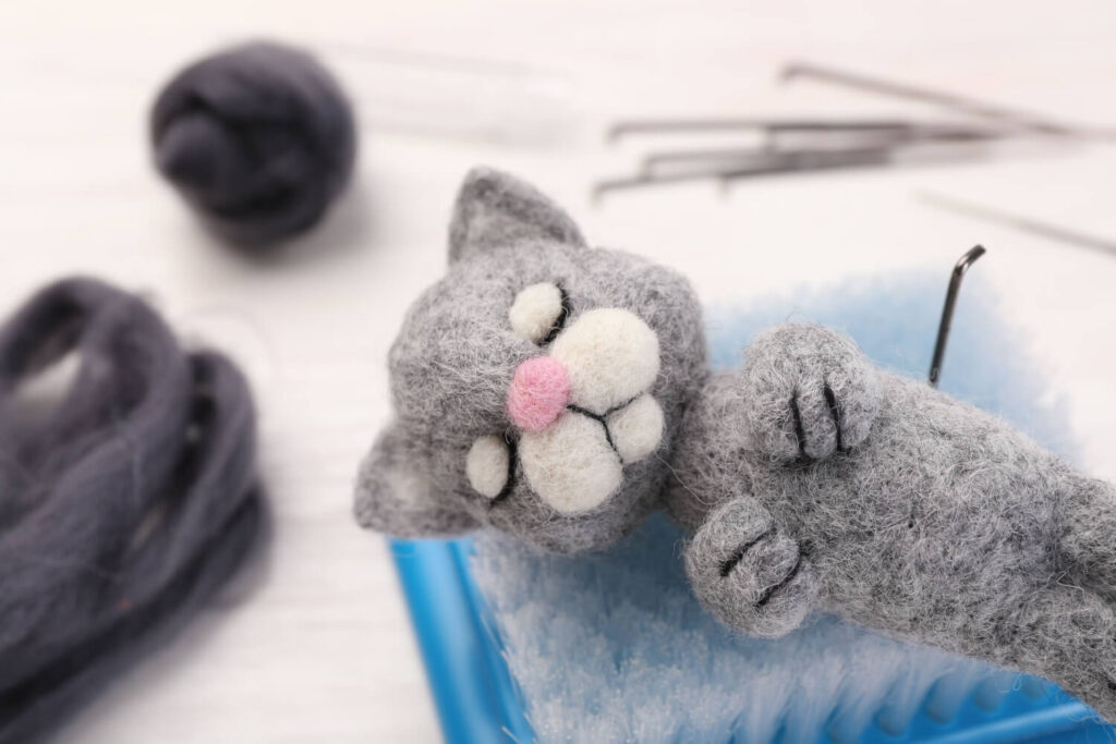 Gray felted cat toy, needle felting supplies.
