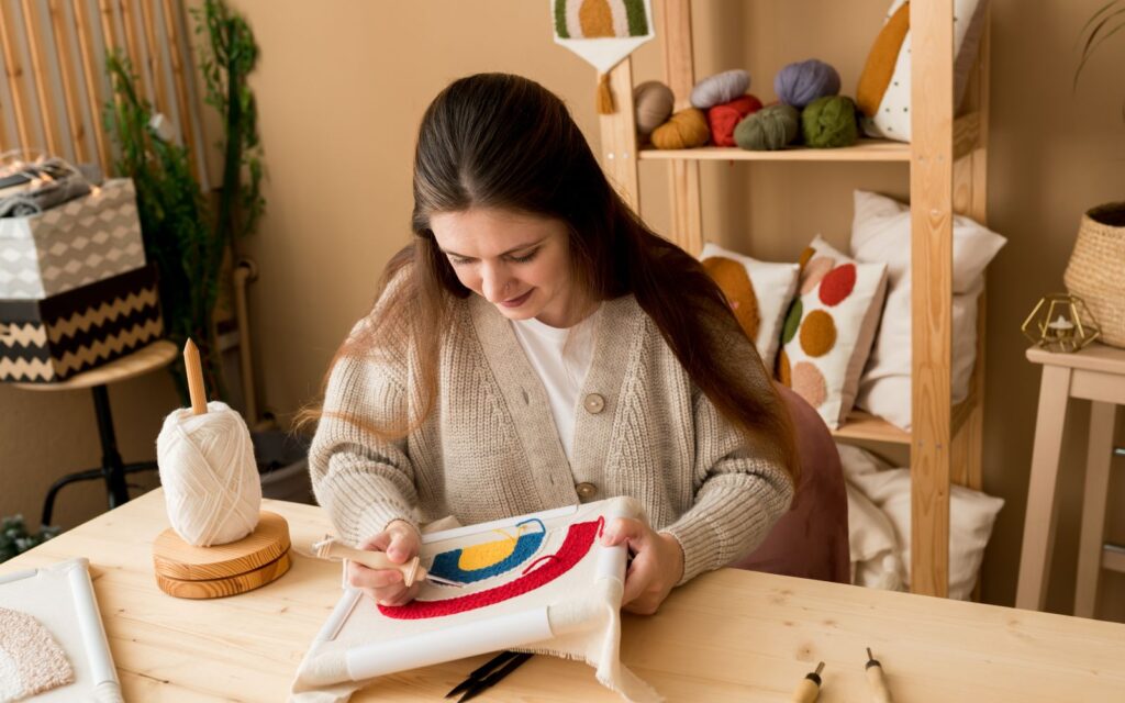 Woman embroidering a colorful design on fabric.